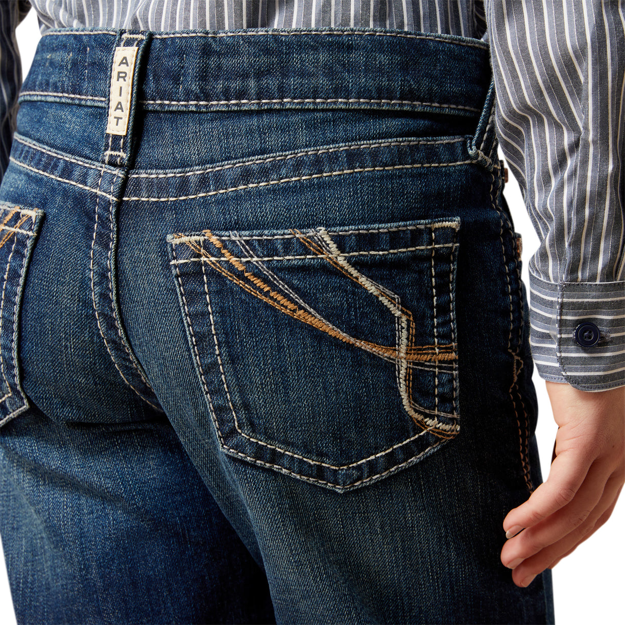 Close-up of blue jeans with a visible brand label on a white background