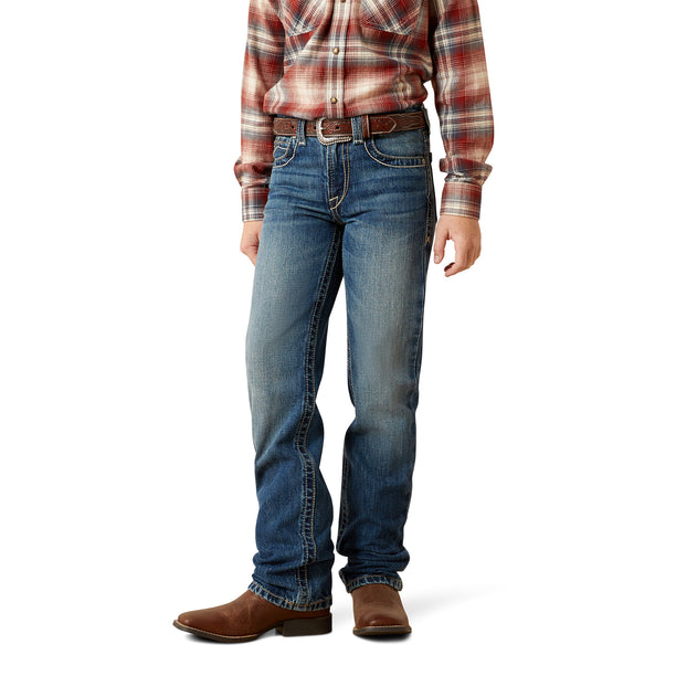 Person wearing blue jeans and a plaid shirt on a white background