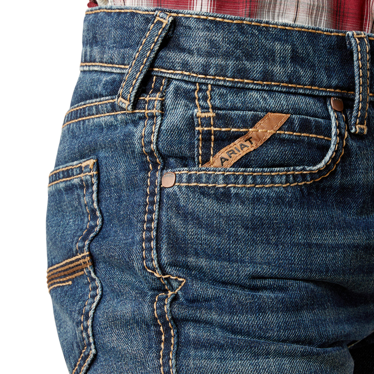 Close-up of blue jeans with ARIAT branding logo on pockets with a white background