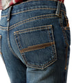 Close-up of blue jeans with a focus on the back pocket on a white background