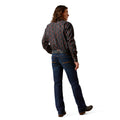 Person wearing a patterned shirt and jeans on a white background