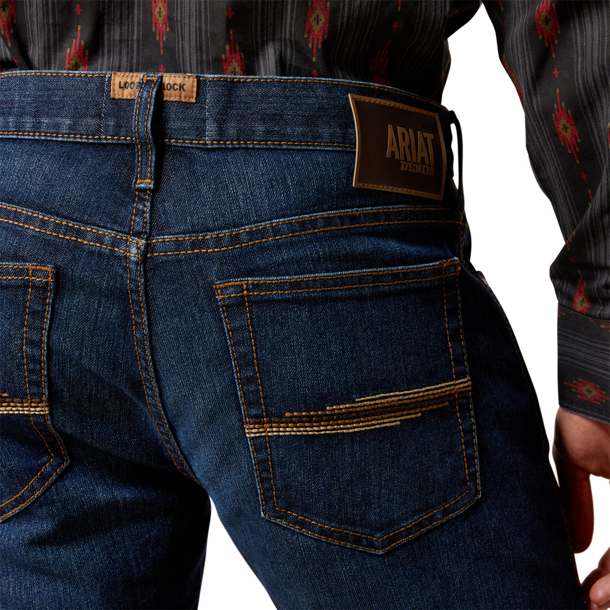 Close-up of blue jeans with Ariat logo on a white background