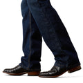 Dark blue jeans worn with brown leather boots on a white background