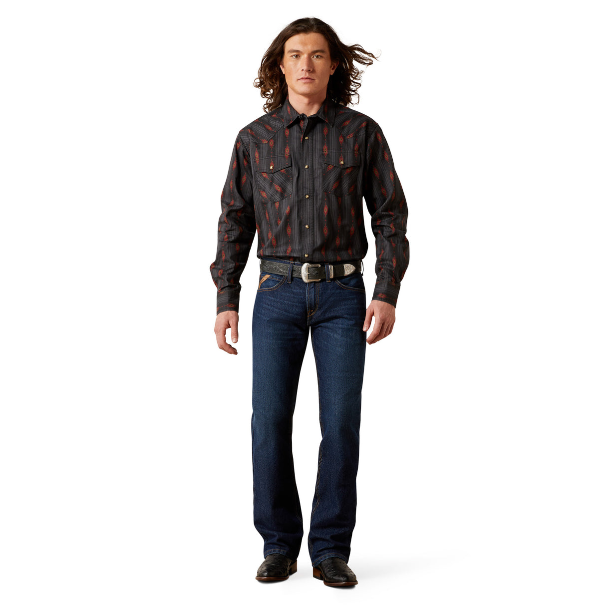 Man wearing a patterned shirt and jeans on a white background