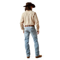 Person wearing a beige shirt, light blue jeans, and a brown hat on a white background