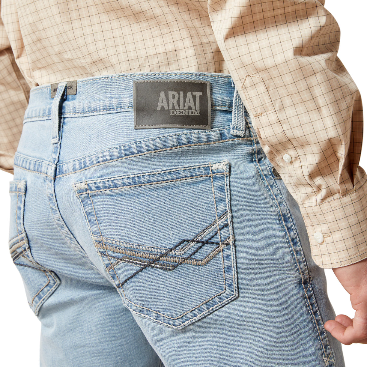 Light blue jeans with Ariat logo on the back pocket, worn by a person.