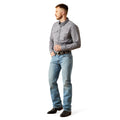 Man wearing a gray checkered shirt and blue jeans on a white background