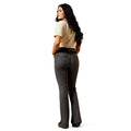 Woman wearing dark jeans and a beige shirt on a white background