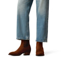 Brown ankle boots worn with blue jeans on a white background