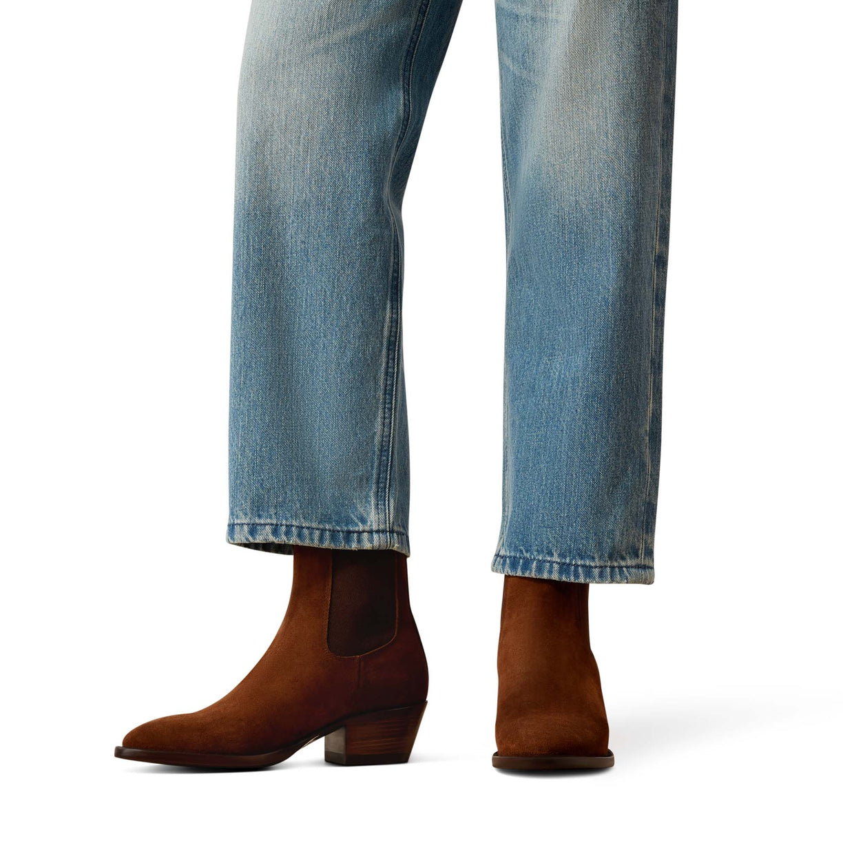 Brown ankle boots worn with blue jeans on a white background