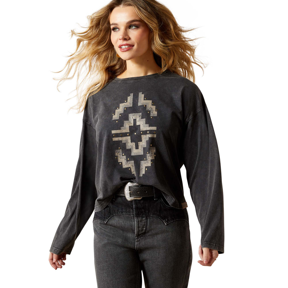 Woman wearing a dark gray long-sleeve shirt with a geometric pattern and jeans on a white background