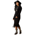 Woman wearing a black dress with fringe, a black hat, and cowboy boots on a white background