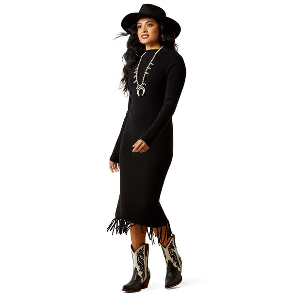 Woman wearing a black dress with fringe, a black hat, and cowboy boots on a white background