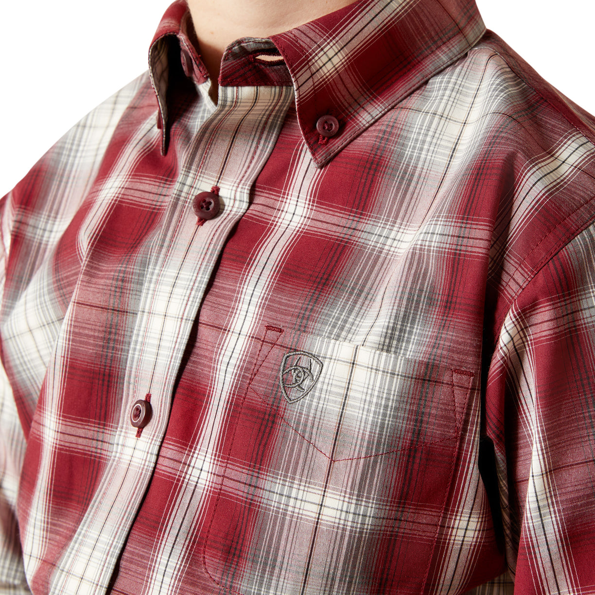 Close-up of a red and white plaid shirt with a brand logo on a white background