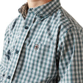 Close-up of a person wearing a green and white plaid shirt with a brand logo on a white background