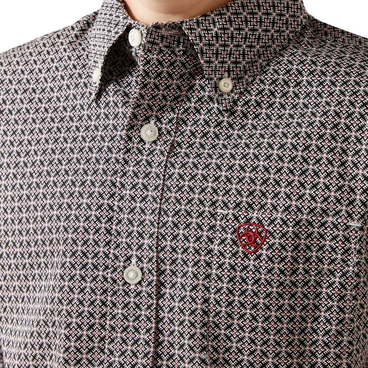 Close-up of a patterned shirt with a red logo on the chest.
