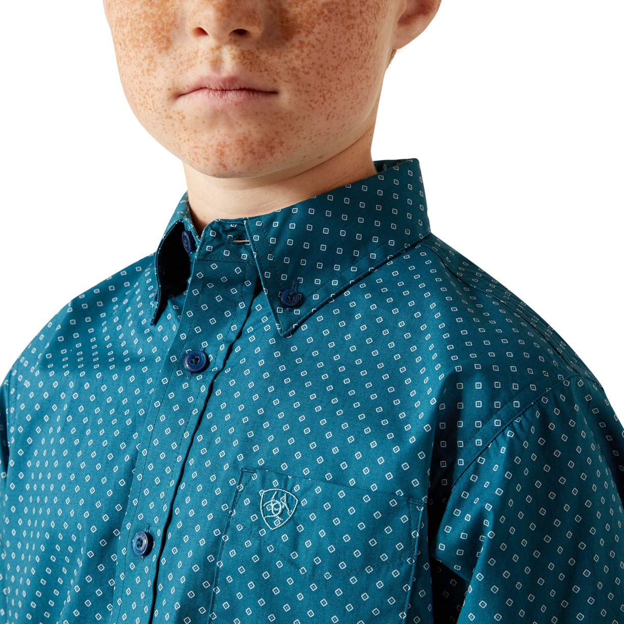 Close-up of a person wearing a teal patterned shirt with a white background