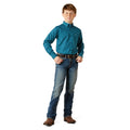 Young boy wearing a blue patterned shirt and jeans on a white background