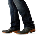 Close-up of dark blue jeans and brown cowboy boots on a white background