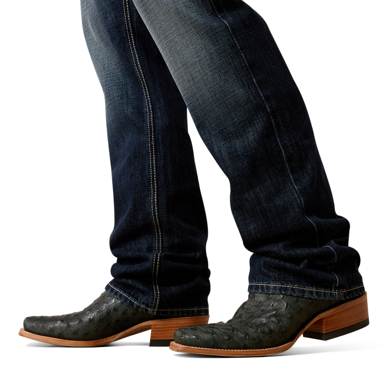 Close-up of dark blue jeans and brown cowboy boots on a white background