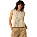 A woman modeling a sleeveless beige graphic tank top with a western skull and cap design, paired with khaki pants, against a plain white background.