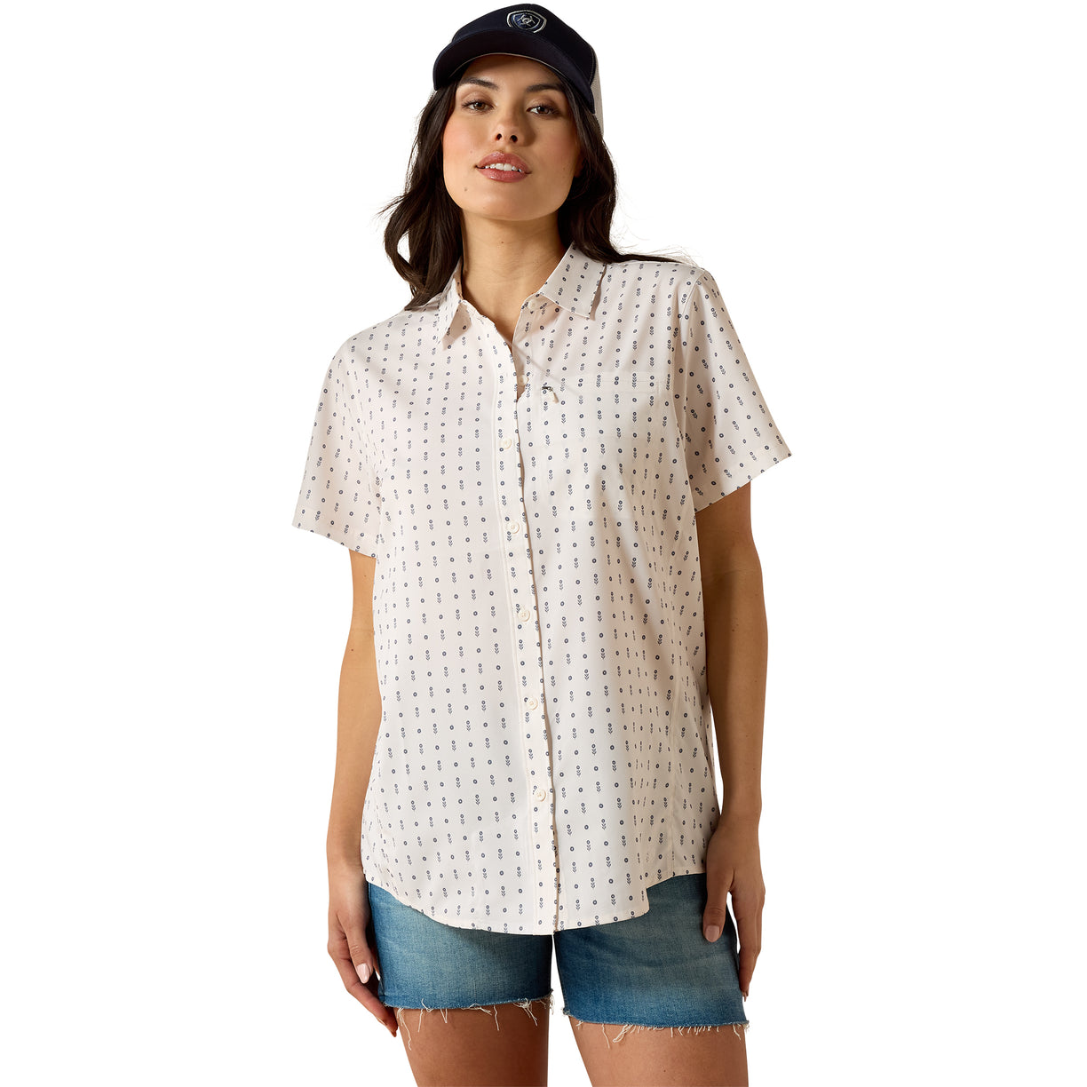 Off-white short-sleeve VentTEK Shirt with a small repeating floral print, styled with denim shorts and a cap.