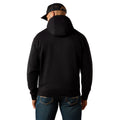 Person wearing a black hoodie and dark jeans on a white background