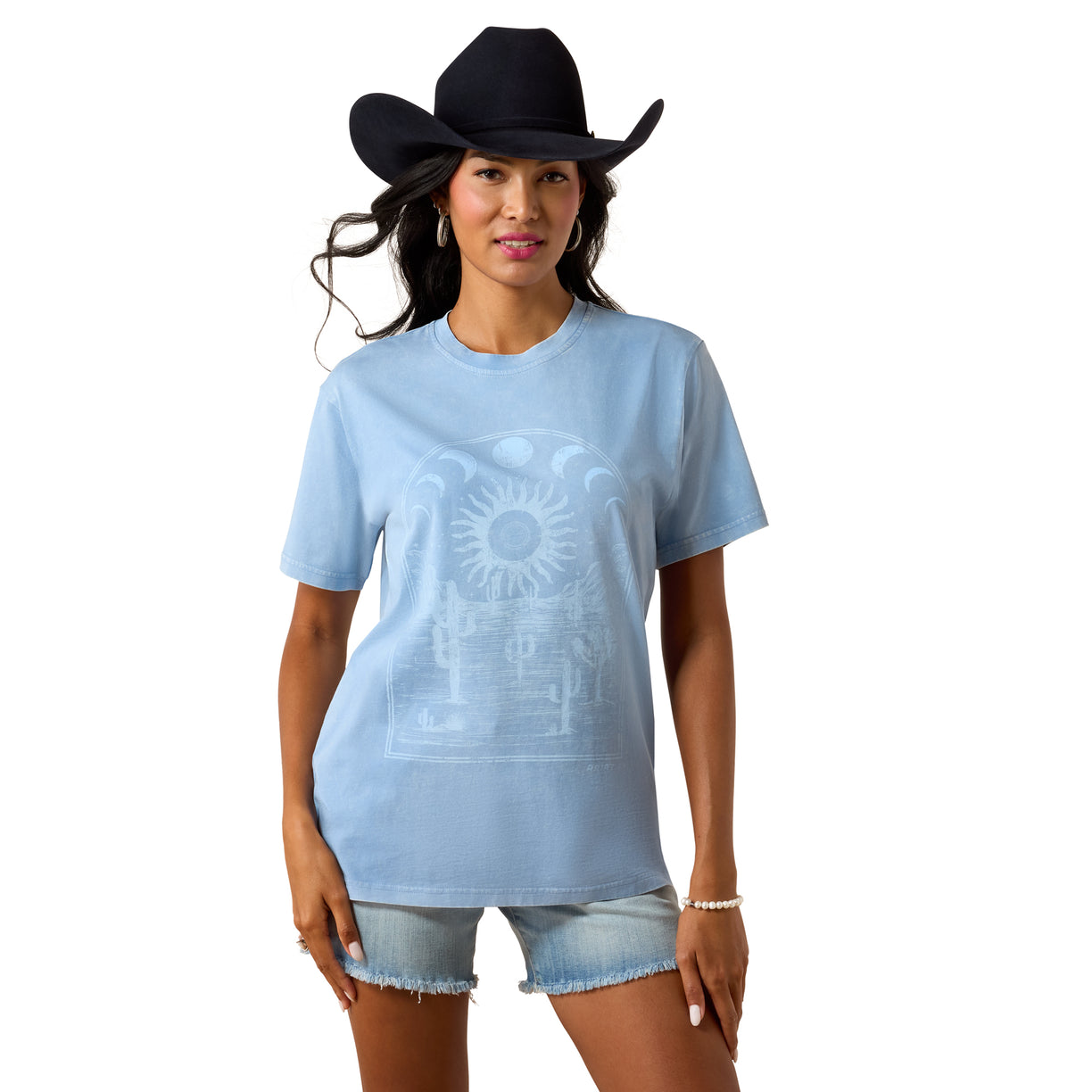 Woman wearing a light blue t-shirt with a design and denim shorts on a white background