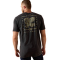 Man wearing a black t-shirt with an eagle design on the back, standing against a white background