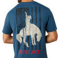 Blue t-shirt with white graphic of a woman on horseback and barbed wire, featuring the Ariat logo.