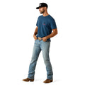 Man wearing a blue t-shirt, jeans, and brown boots on a white background
