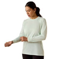 Mint green long sleeve active top with tonal shoulder branding, worn with black leggings