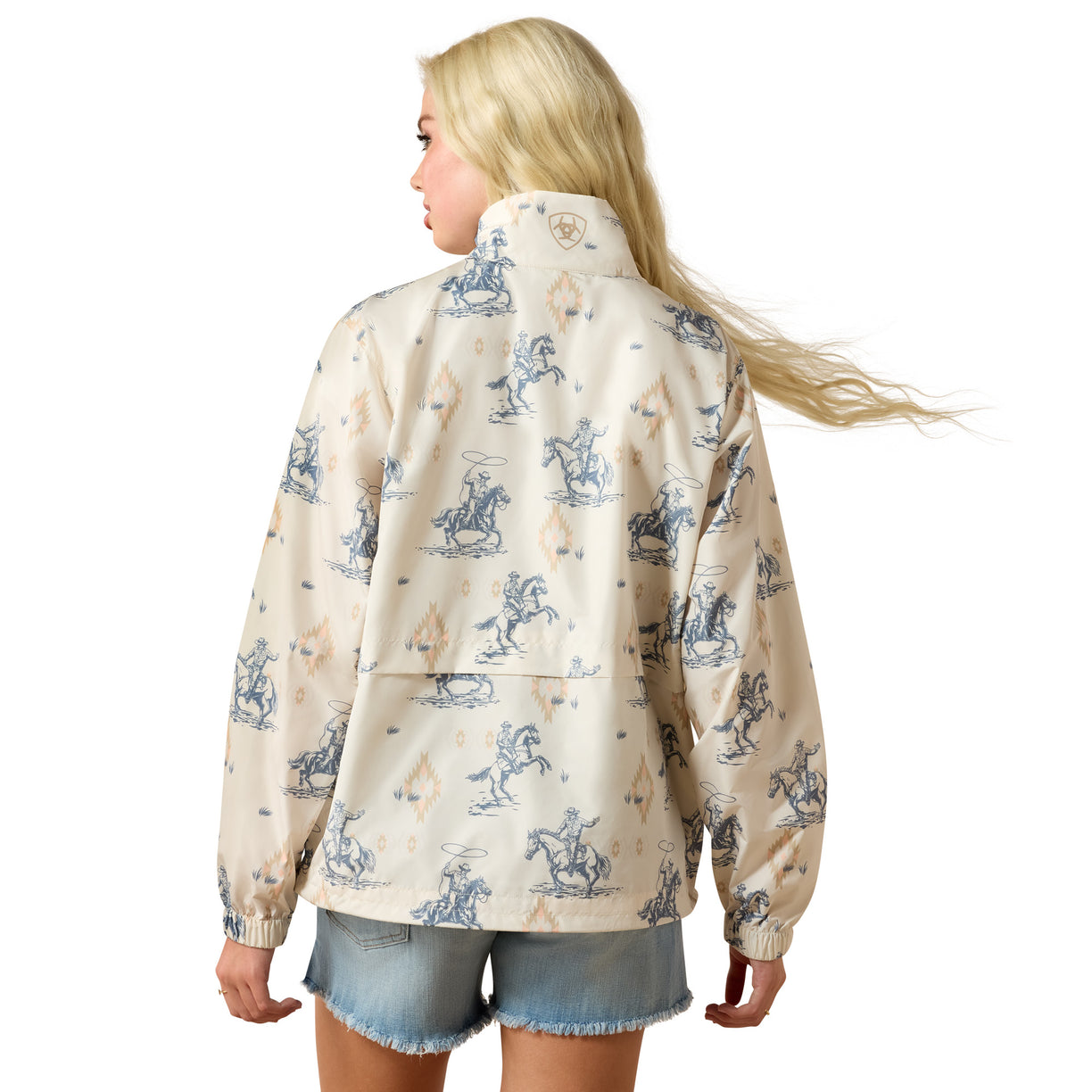 Woman wearing a patterned jacket with horse and rider design on a white background