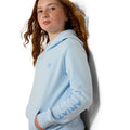 Person wearing a light blue hoodie with 'Ariat' branding on a white background