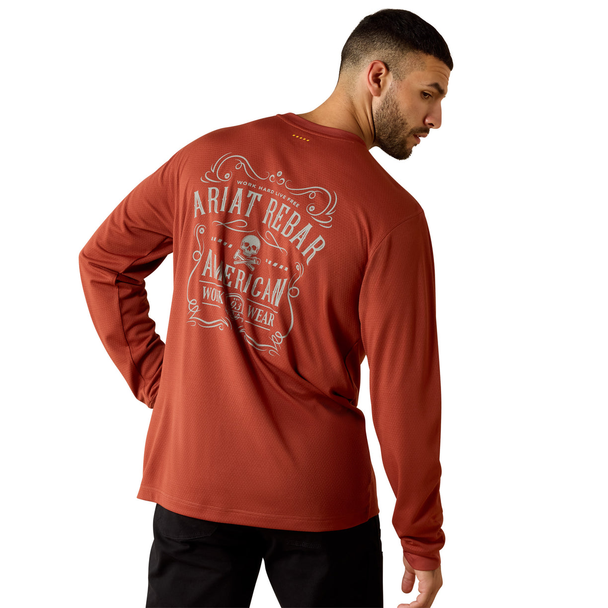 Man wearing a rust-brown long sleeve tee with a vintage American Workwear badge graphic on the back