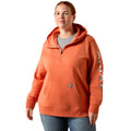 Person wearing an orange hoodie with a brand logo on a white background