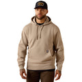 Man wearing a beige hoodie and black cap on a white background