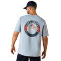 Ariat Work circular graphic printed on the back of the Rebar Cotton Strong Skull T-Shirt in light blue, worn with a cap, back view