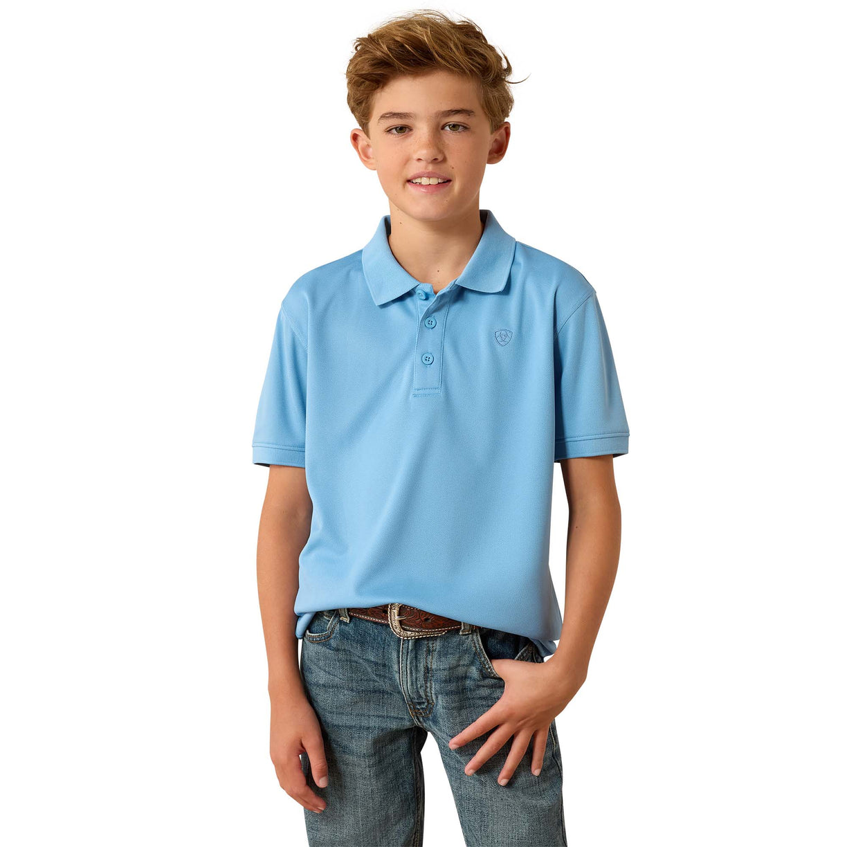 A young boy modeling a light blue short-sleeve polo shirt with blue jeans, standing against a solid white background.
