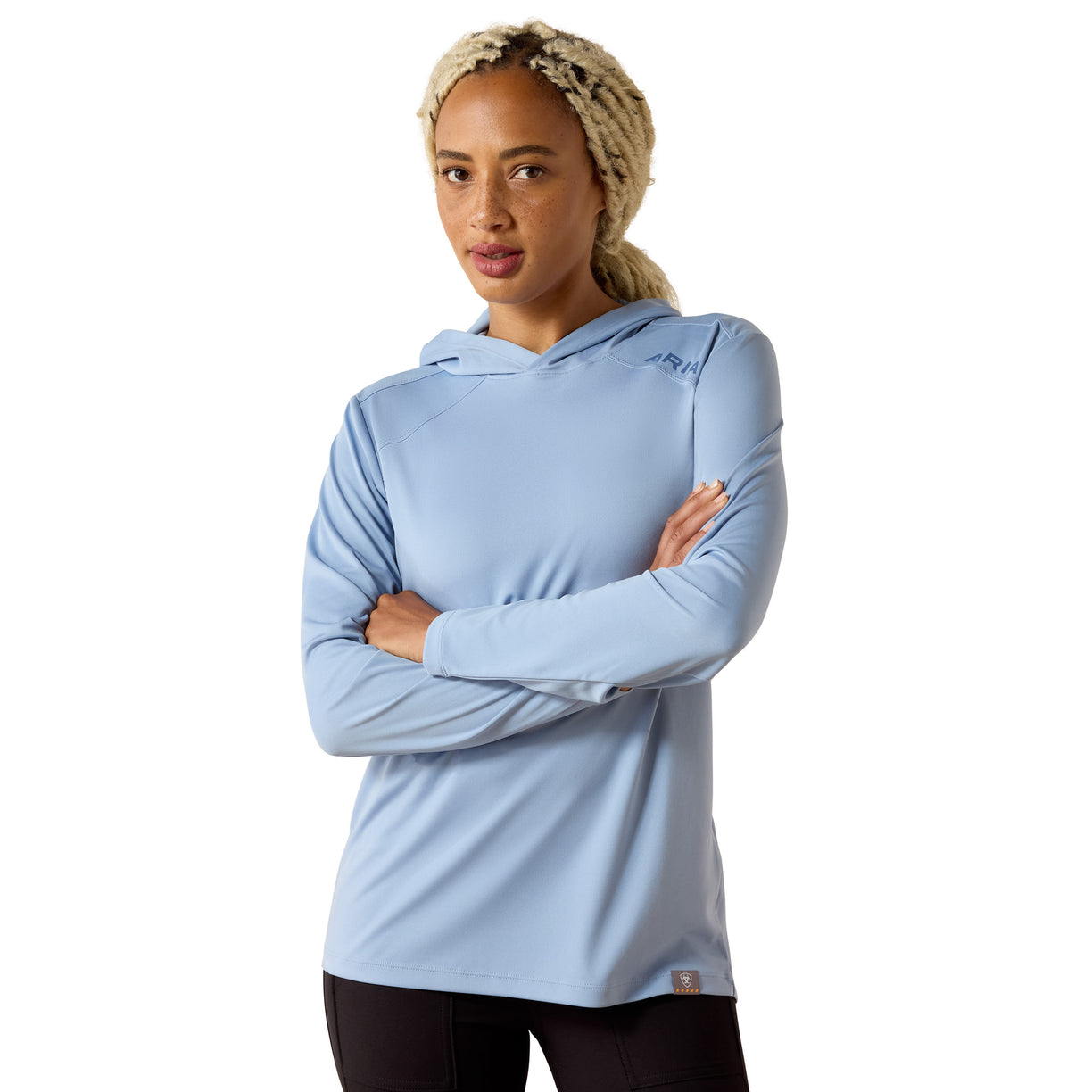 Light blue hooded long-sleeve top with ARIAT logo at the shoulder - the Rebar Sunblocker Hooded T-Shirt, woman wearing black leggings