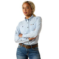 Woman wearing a light blue long sleeve work shirt with snap buttons