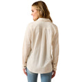 Woman wearing a beige long-sleeve shirt on a white background