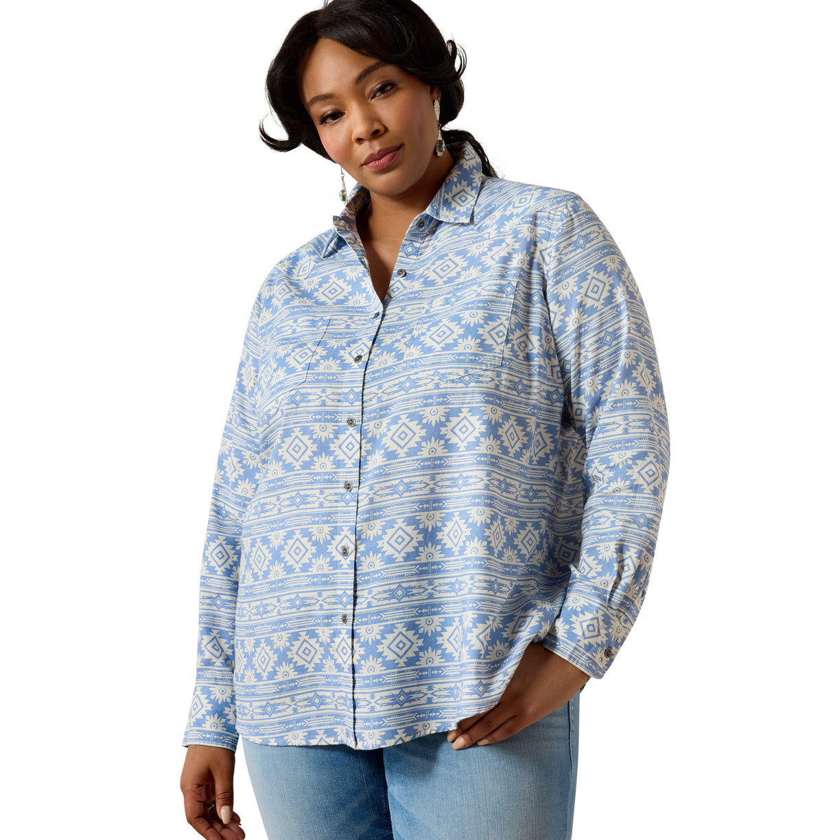 A woman modeling a light blue and white patterned button-down shirt with light-wash jeans against a plain white background.