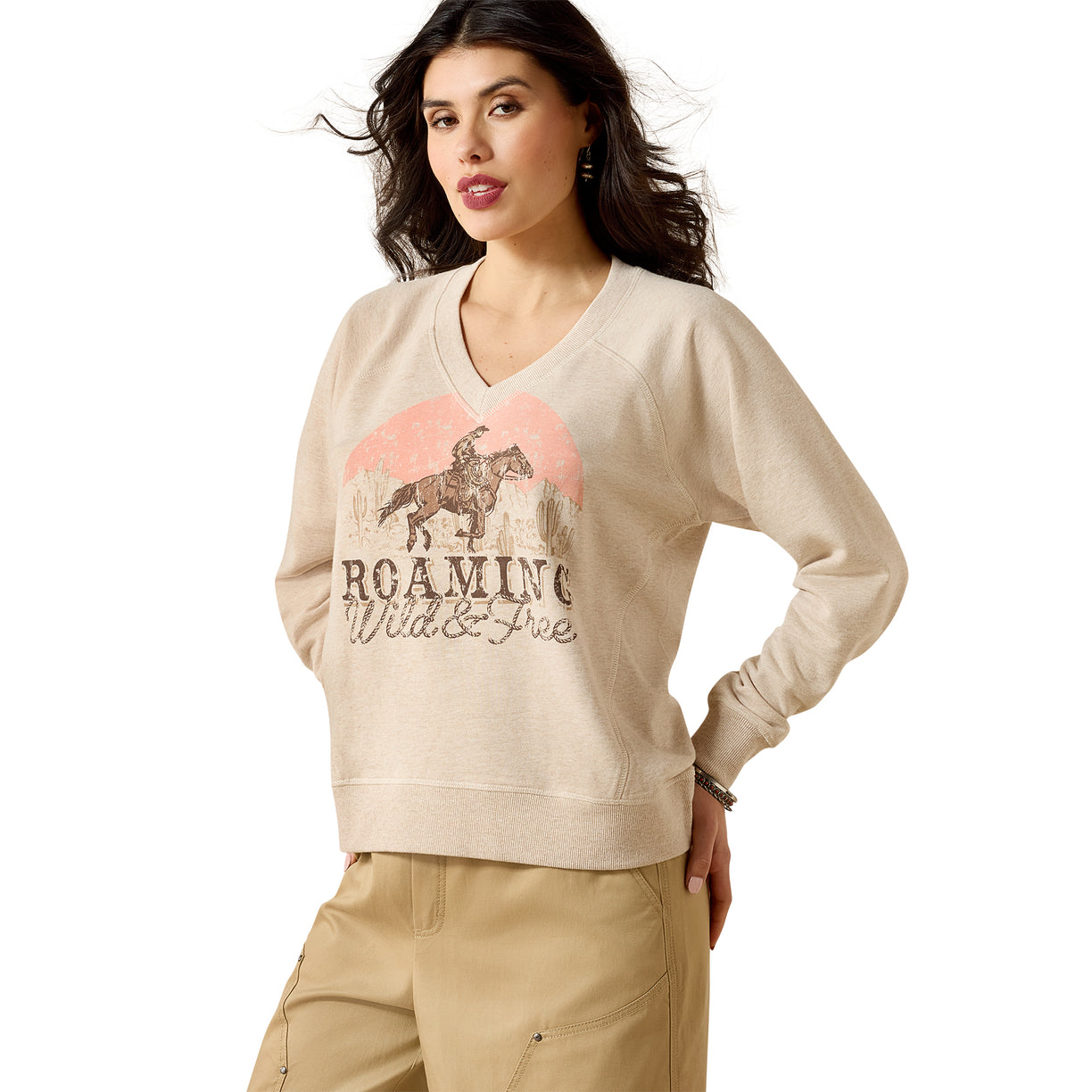 Woman wearing a beige sweatshirt with a graphic design on a white background