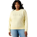 Woman wearing a light yellow 'Ariat' sweatshirt on a white background
