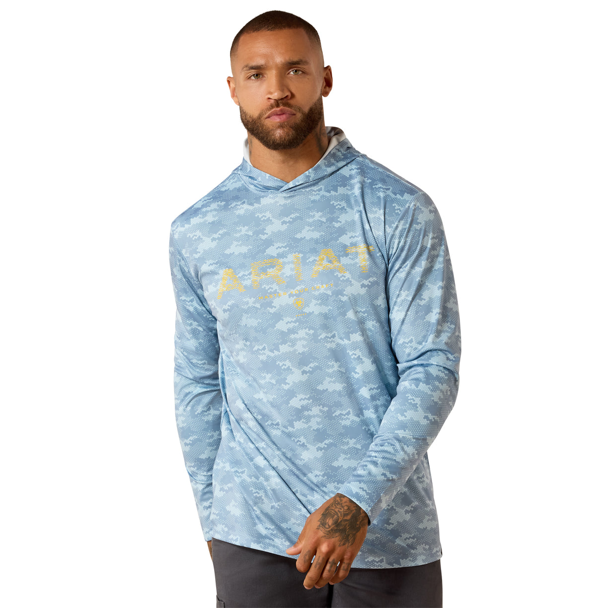 Man wearing an Ariat hooded long sleeve tee in blue camo print with gold logo graphic