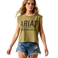 Woman wearing a green 'Ariat' sleeveless shirt with denim shorts on a white background