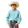 A young cowboy wearing a light blue plaid western shirt, jeans, and a cowboy hat