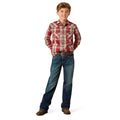 A young boy modeling a red and beige plaid long-sleeve western shirt with blue jeans, brown belt, and brown boots, standing against a solid white background.