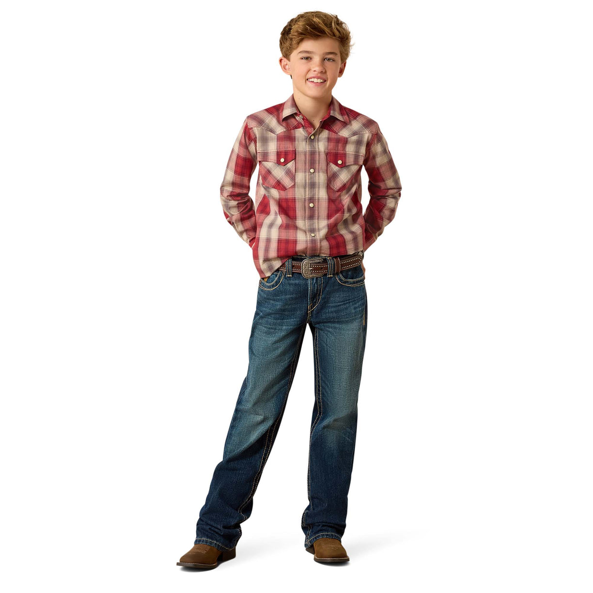 A young boy modeling a red and beige plaid long-sleeve western shirt with blue jeans, brown belt, and brown boots, standing against a solid white background.